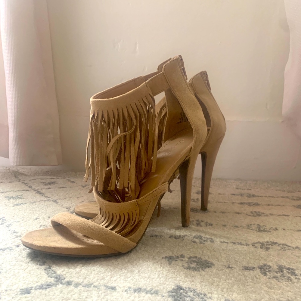 Nude sandal heels with fringe.